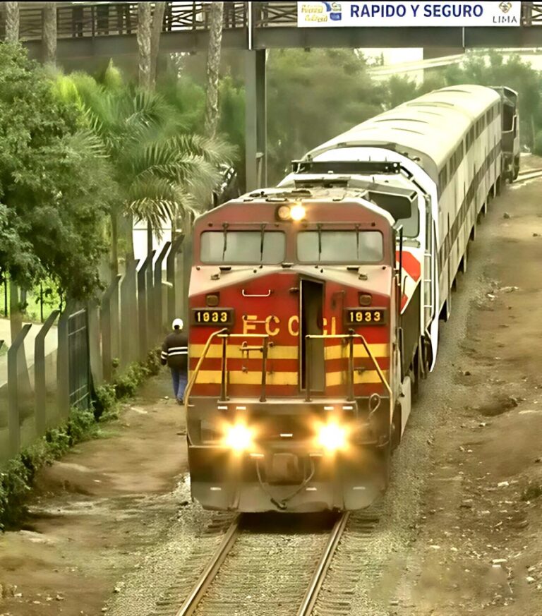 Locomotive diesel rouge et jaune numéro 1933 tractant des voitures voyageurs sur une voie à Lima, sous une passerelle portant l’inscription « Rápido y seguro »